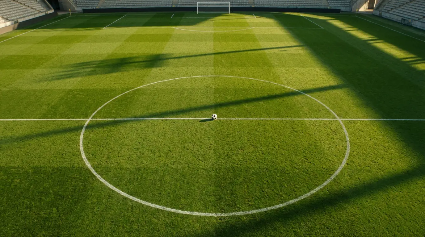 Campo da calcio in erba visto dall'alto con linee bianche e pallone al centro del cerchio